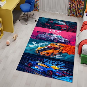 May include: A rectangular rug featuring stylized illustrations of four sports cars. The cars are in red, purple, orange, and blue, with text including "Lancer Evo", "GT R", "Supra", and "BRZ Subaru". The rug has a dark blue and teal background.
