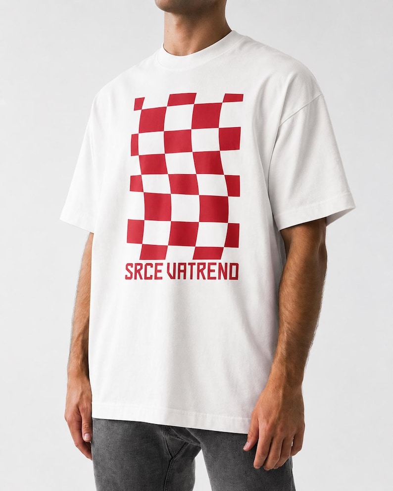 May include: A white short-sleeve t-shirt featuring a red and white checkered pattern that appears distorted or wavy in the center. Below the graphic, the text SRCE VATREND is printed in a bold, red, sans-serif font on the chest area.