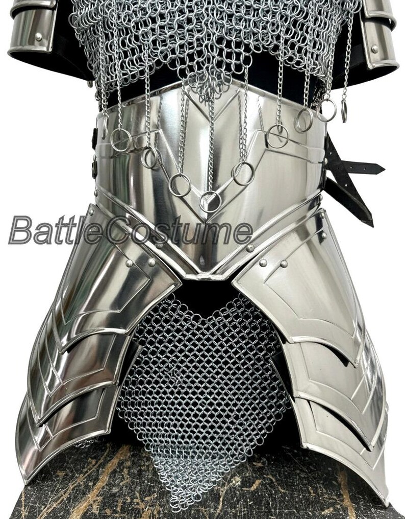 Puede incluir: Una armadura de pecho y cintura de metal plateado pulido con detalles de cota de malla. La armadura presenta placas en capas y anillos decorativos, con el texto "Battle Costume" visible en la parte delantera. El dise&ntilde;o sugiere un tema medieval o de fantas&iacute;a.