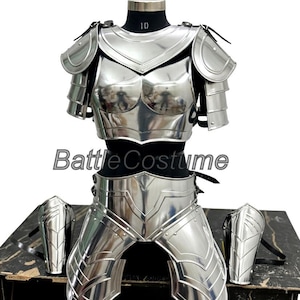 May include: A complete set of polished silver armor, including a breastplate, shoulder guards, and leg armor, displayed on a mannequin. The armor is highly reflective and features intricate detailing. The text "Battle Costume" is visible.