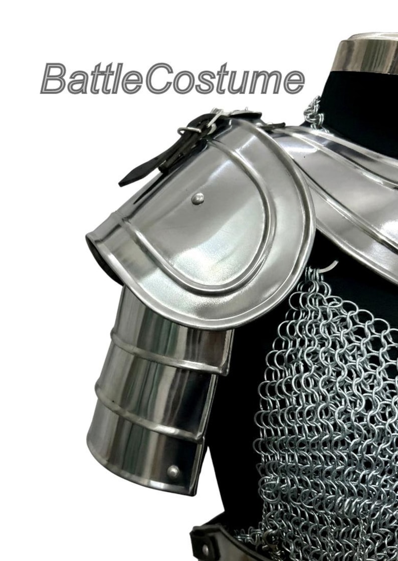 Puede incluir: Primer plano de una armadura de hombro medieval plateada con cota de malla. La armadura tiene un acabado pulido y est&aacute; hecha de metal. El texto "BattleCostume" es visible en la esquina superior izquierda.