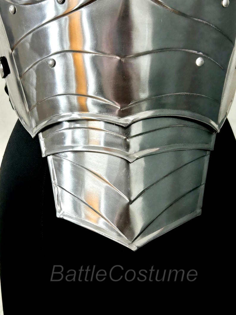 May include: Close-up of a polished, silver chest armour piece. The armour has a layered design with riveted details and a reflective surface. The text "BattleCostume" is visible at the bottom. This item is likely for cosplay or historical reenactment.