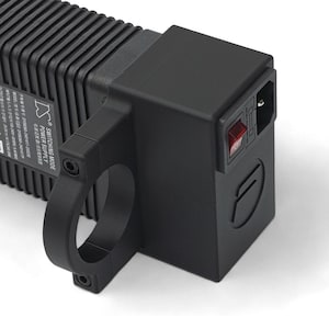 May include: Black power supply with a red power switch and a circular handle. The power supply has a ridged design and a logo on the side. The text "SWITCHING MODE POWER SUPPLY" is visible.