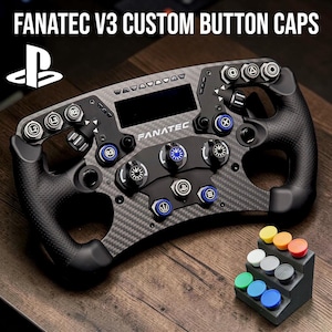 Può includere: Un volante personalizzato Fanatec V3 nero e grigio con più pulsanti e un piccolo display. Il volante ha un design in fibra di carbonio e un set di cappucci colorati per pulsanti su un piccolo supporto. Il testo "FANATEC V3 CUSTOM BUTTON CAPS" è visibile.