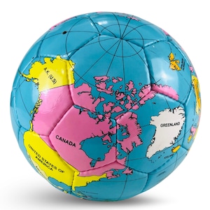 Puede incluir: Balón de fútbol azul con diseño de mapa del mundo. Los continentes son rosas y amarillos, con nombres de países. Líneas negras representan la cuadrícula.