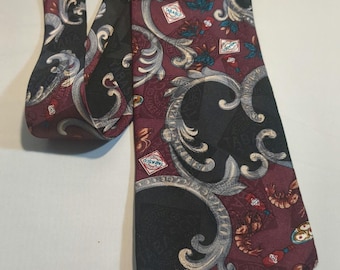 May include: A dark red, black, and silver patterned silk tie with a paisley design. The tie features a repeating pattern of stylized floral motifs and small images of shrimp and seafood.