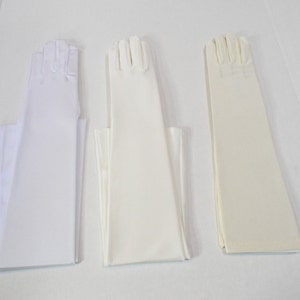 Puede incluir: Tres pares de guantes largos blancos, un par es marfil, un par es blanco y un par es de un tono blanco m&aacute;s claro.