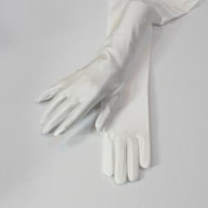 Puede incluir: Un par de guantes largos de sat&eacute;n blanco. Los guantes est&aacute;n doblados por la mitad y las yemas de los dedos se tocan.