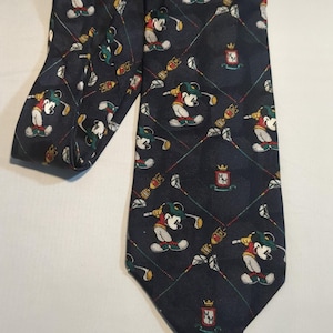 May include: A black silk tie with a repeating pattern of Mickey Mouse playing golf. The pattern also includes golf clubs, golf balls, and a crest with the letters "MM".