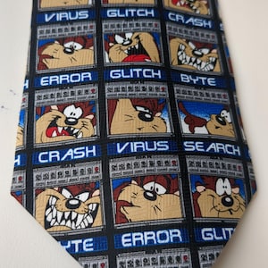May include: A black tie with a repeating pattern of Taz the Tasmanian Devil in a computer screen with various computer terms like "Glitch", "Virus", "Error", "Search", "Crash", and "Byte".