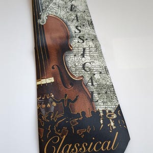 May include: A necktie featuring a brown violin illustration with musical notes and the word "CLASSICAL" in gold. The background has a map-like design. The tie is a classic accessory for music lovers.