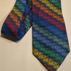 May include: A dark blue necktie with a repeating pattern of colorful fish with the word "WWW.JD" inside each fish.