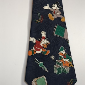 May include: A dark blue silk tie with a repeating pattern of Disney characters, including Mickey Mouse, Donald Duck, and Goofy. The characters are depicted in various office settings, such as working at a computer, using a phone, and reading a book. The tie is a fun and whimsical accessory for any Disney fan.