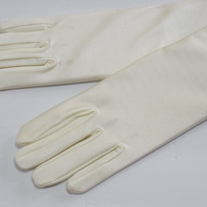 Puede incluir: Un par de guantes largos de sat&eacute;n blanco. Los guantes son lisos y tienen una textura sedosa.