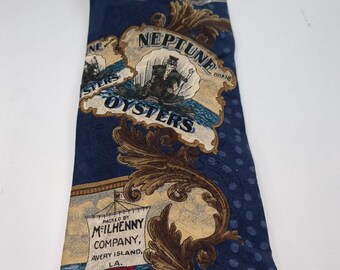Puede incluir: Corbata azul marino con diseño de Tabasco y ostras. La corbata presenta el logotipo de la marca Tabasco, una botella roja y las palabras "Neptune Oysters". La corbata también tiene un patrón repetitivo de pequeños puntos azules.