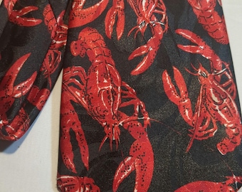 Puede incluir: Una corbata de seda negra con estampado de langosta roja. Las langostas están dispuestas en un patrón repetitivo en toda la corbata.