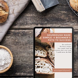 Könnte beinhalten: Ein rustikaler Holztisch zeigt Sauerteigbrot, eine Schüssel mit Mehl und ein Brotmesser. Ein Tablet zeigt den Text "SOURDOUGH MADE SIMPLE: A BEGINNER'S PATH TO SUCCESS" mit dem Text "No confusion. No fancy jargon."