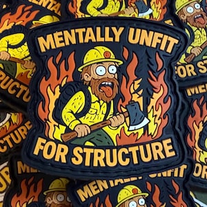 May include: Black patch with the text "MENTALLY UNFIT FOR STRUCTURE" and a cartoon firefighter character with an axe, surrounded by flames. The firefighter wears a yellow helmet and uniform. The patch is approximately 3 inches wide.