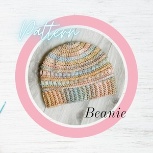 May include: A crocheted beanie featuring a variegated yarn in pastel shades of pink, yellow, blue, and cream. The hat displays a textured design with horizontal rows of puff stitches and a ribbed brim. The image includes the text Pattern Beanie.