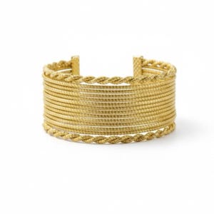 May include: A wide gold cuff bracelet featuring a multi-strand design. The piece consists of ten parallel smooth wire strands in the center, flanked by a single twisted rope-style wire strand along both the top and bottom edges of the cuff.