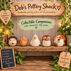 May include: Five small ceramic animal figurines displayed on a wooden shelf. The figures include a brown hedgehog, an orange fish, a white bird, a brown owl, and a white and brown dog. Signs feature text including Deb's Pottery Shack and Collectible Companions.