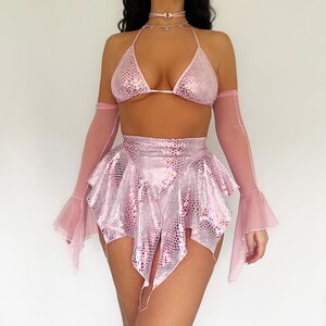 May include: A pink two-piece outfit, comprising a halter top and a skirt, with a scale-like texture. The ensemble includes sheer arm sleeves and a choker. This outfit is suitable for festivals or parties, offering a bold, eye-catching look.