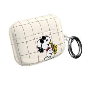 May include: White AirPod case with a grid pattern and a cartoon Snoopy playing a saxophone. The case has a silver carabiner clip for easy attachment. The Snoopy graphic features black, white, red, and yellow colors.