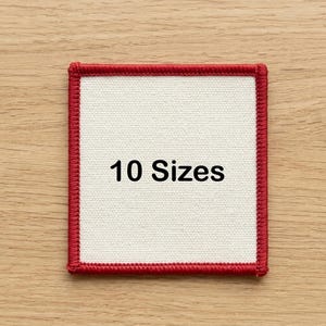 May include: Square patch with a cream-colored center and a red border. The text "10 Sizes" is printed in black across the center of the patch. The patch is on a light brown wooden surface.