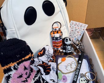 May include: A white ghost-shaped backpack, fuzzy black and orange socks, a patterned scrunchie, a hand sanitizer holder, a skeleton figurine, a beaded bracelet, ghost earrings, a pen labeled BOO BOO BOO, a ghost keychain, and a notepad.