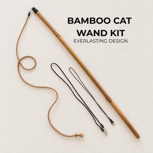 May include: A bamboo cat wand kit featuring a long, slender bamboo rod, a thick tan rope attached to the end, and two thin black cords with metal clips. The text BAMBOO CAT WAND KIT EVERLASTING DESIGN is printed in black on the right side.