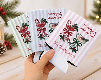 Könnte beinhalten: Drei Dosenkühler aus Schaumstoff mit vertikalen Streifen in Pastellgrün, Blau und Rosa. Jeder Kühler zeigt zwei Cocktailgläser mit Zuckerstangen, Stechpalmen und roten Schleifen sowie den Text merry & married und The Smiths 2026.