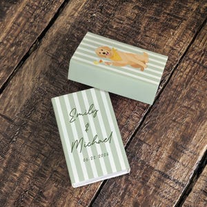 May include: Two matching boxes with a light green and white striped pattern. One box has a cartoon dog illustration. The other box has the names "Emily & Michael" and the date "06.22.2026" printed on it.