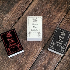 May include: Three matchbox-style party favors with a disco ball design and the text "David's 30th Birthday". One box is black with red text, one is white with black text, and one is black with white text.