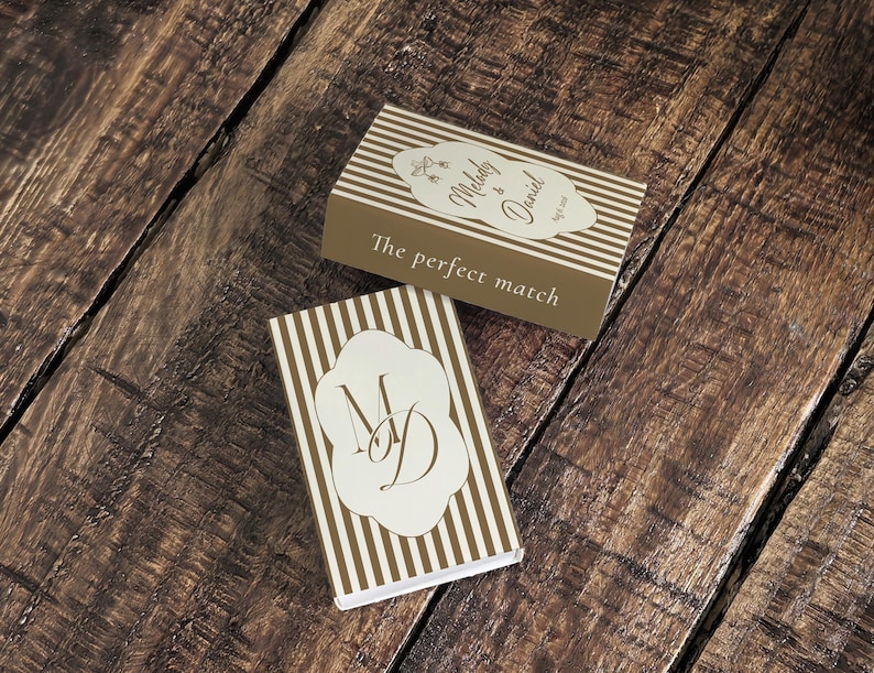 Peut inclure: Deux bo&icirc;tes d'allumettes rectangulaires avec un motif &agrave; rayures verticales marron et blanc. L'une affiche le texte Melody & Daniel avec la date et la phrase The perfect match. L'autre pr&eacute;sente une &eacute;tiquette festonn&eacute;e blanche avec les initiales MD.