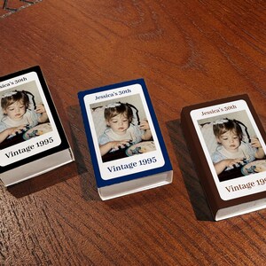 May include: Three small, rectangular boxes with a photograph of a young child. Each box has a different colored border: black, blue, and brown. The text "Jessica's 30th" and "Vintage 1995" are printed on each box.