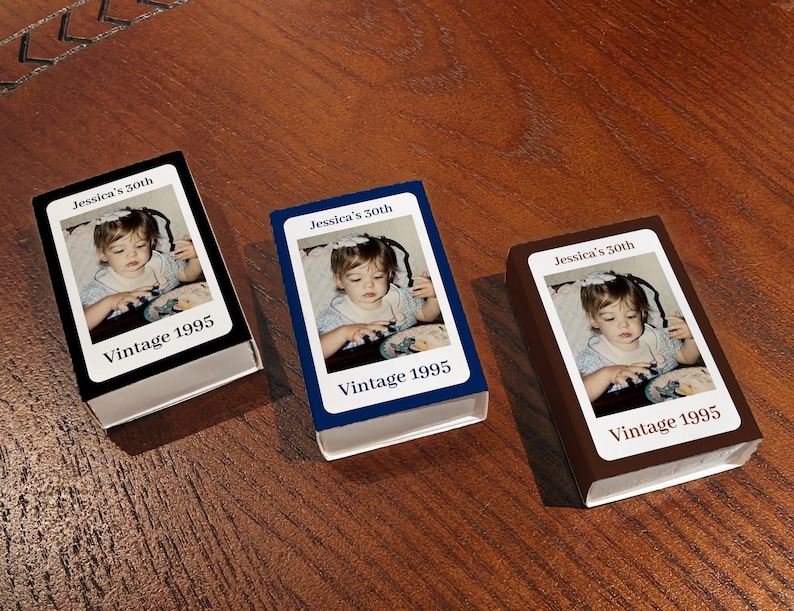 May include: Three small, rectangular boxes with a photograph of a young child. Each box has a different colored border: black, blue, and brown. The text "Jessica's 30th" and "Vintage 1995" are printed on each box.
