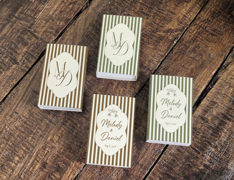 Peut inclure: Quatre bo&icirc;tes d'allumettes rectangulaires &agrave; rayures verticales vert olive ou marron. Deux bo&icirc;tes pr&eacute;sentent le monogramme MD sur une &eacute;tiquette festonn&eacute;e blanche. Deux bo&icirc;tes portent le texte Melody & Daniel avec une date et un motif.