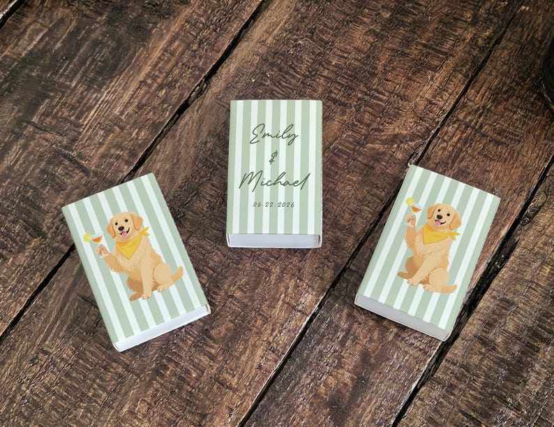 May include: Three matchboxes with a light green and white striped pattern. Two boxes feature a golden retriever illustration holding a cocktail. The center box has the names "Emily & Michael" and the date "06.22.2026" in black script.