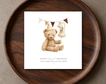 May include: A square greeting card featuring a brown teddy bear wearing a polka-dot party hat. The bear holds a balloon shaped like the number one with the name Theo written on it. A banner above reads ONE. Text below reads HAPPY Beary 1ST BIRTHDAY TO A SPECIAL LITTLE BOY.