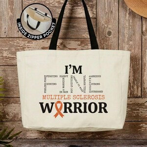 May include: A cream-colored canvas tote bag with black handles and an inside zipper pocket. The front features black text reading I'M FINE, with smaller words like SLEEPY, HURTING, and ANXIOUS, plus orange text reading MULTIPLE SCLEROSIS WARRIOR.