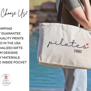 Pu&ograve; includere: Una borsa tote in tela color crema con spallacci neri. La parte anteriore della borsa presenta la parola pilates in corsivo nero con un piccolo cuore rosa sopra la lettera s, seguita dal nome EMMA in lettere stampate nere.