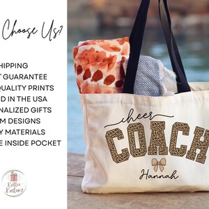 May include: A cream-colored tote bag with black handles, featuring the words "cheer COACH" in a leopard print design, with the name "Hannah" below. The bag contains a patterned blanket and towel.