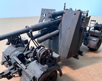 May include: A detailed model of an anti-aircraft gun, featuring a dark gray and brown color scheme. The model includes intricate details such as the gun barrel, wheels, and various mechanical components. The model is set against a neutral background.