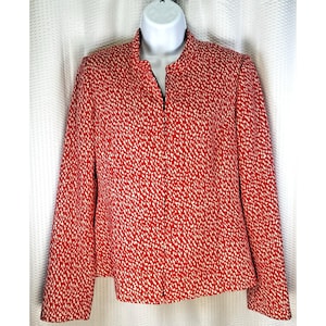 May include: Red jacket with a white speckled pattern. The jacket has a mandarin collar and a full-length zipper. The sleeves are long, and the jacket is displayed on a white mannequin.