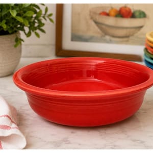 May include: A bright red ceramic bowl with a smooth, glossy finish and concentric ring detailing around the exterior rim. The bowl features a wide, circular opening and a deep basin, showcasing a vibrant solid color throughout the entire piece.