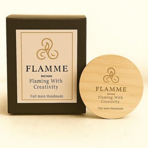a black box and a wooden coaster with the word "FLAMME" printed on them.