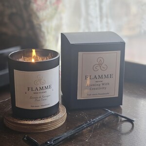 a candle and its packaging on a wooden surface.