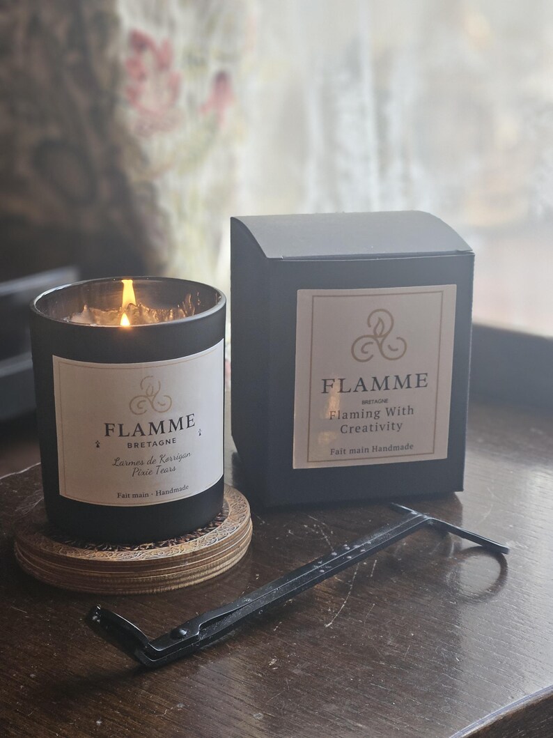a candle and its packaging on a wooden surface.