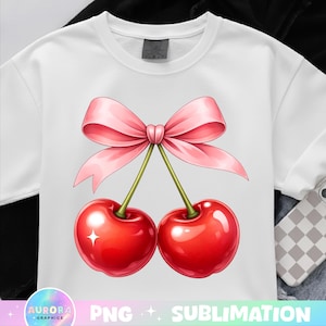 May include: White t-shirt with a colourful illustration of two glossy red cherries tied with a pink bow. The cherries have green stems and a sparkling highlight. The design is a playful and colourful graphic.