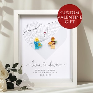 Peut inclure: Cadre blanc avec une carte de Toronto, Canada, en forme de cœur, ornée de figurines Lego. Les noms "Lucia & Davie" et la date 05.04.2025 sont en dessous. Un cercle rouge indique "Custom Valentine Gift".